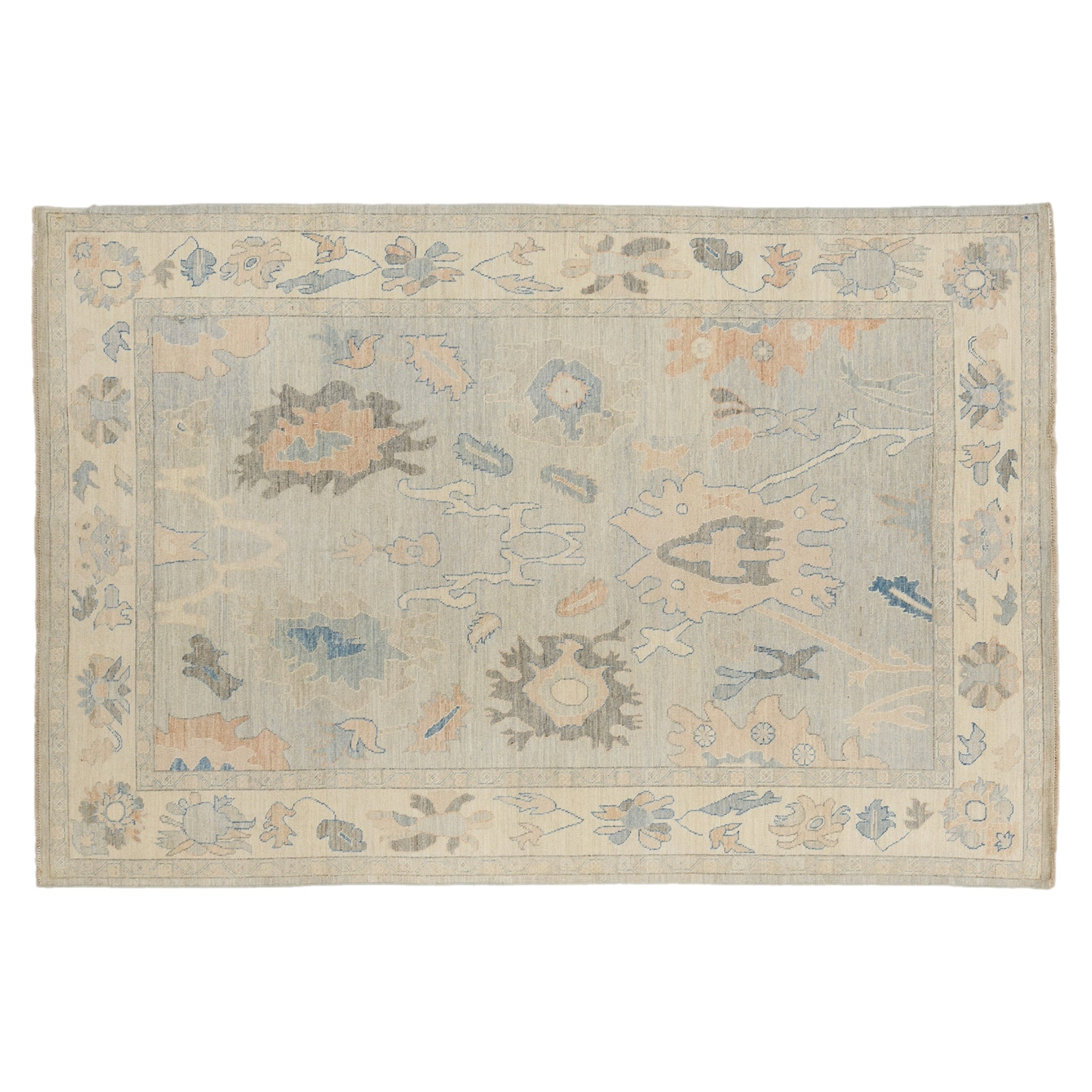Airy light blue 6x9 Oushak area rug with blush pink floral palmettes and a wide cream border.