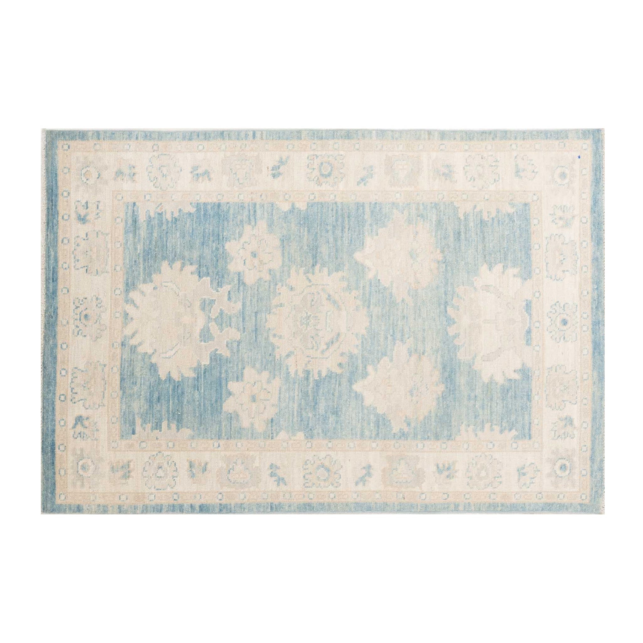 Vibrant medium blue 4x6 Oushak area rug with warm beige geometric star medallions and a distressed cream border.