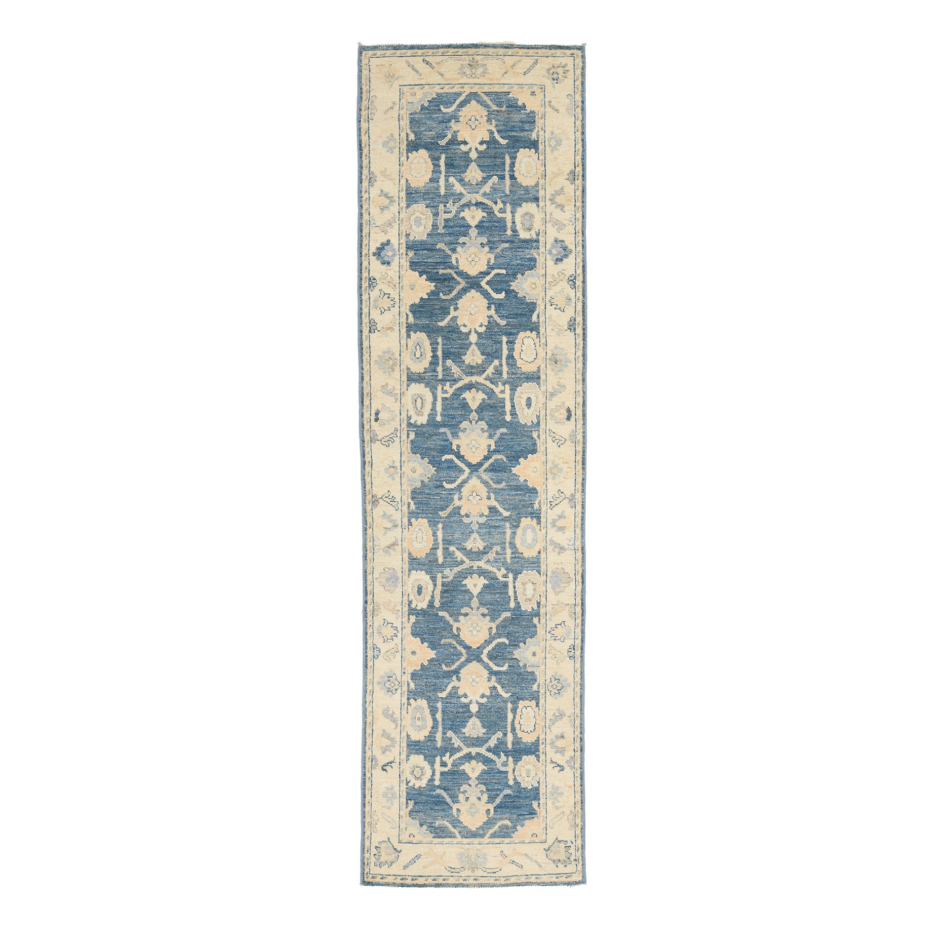 Traditional dark blue Oushak runner rug with soft peach and beige floral medallions, ivory borders, and a distressed finish.