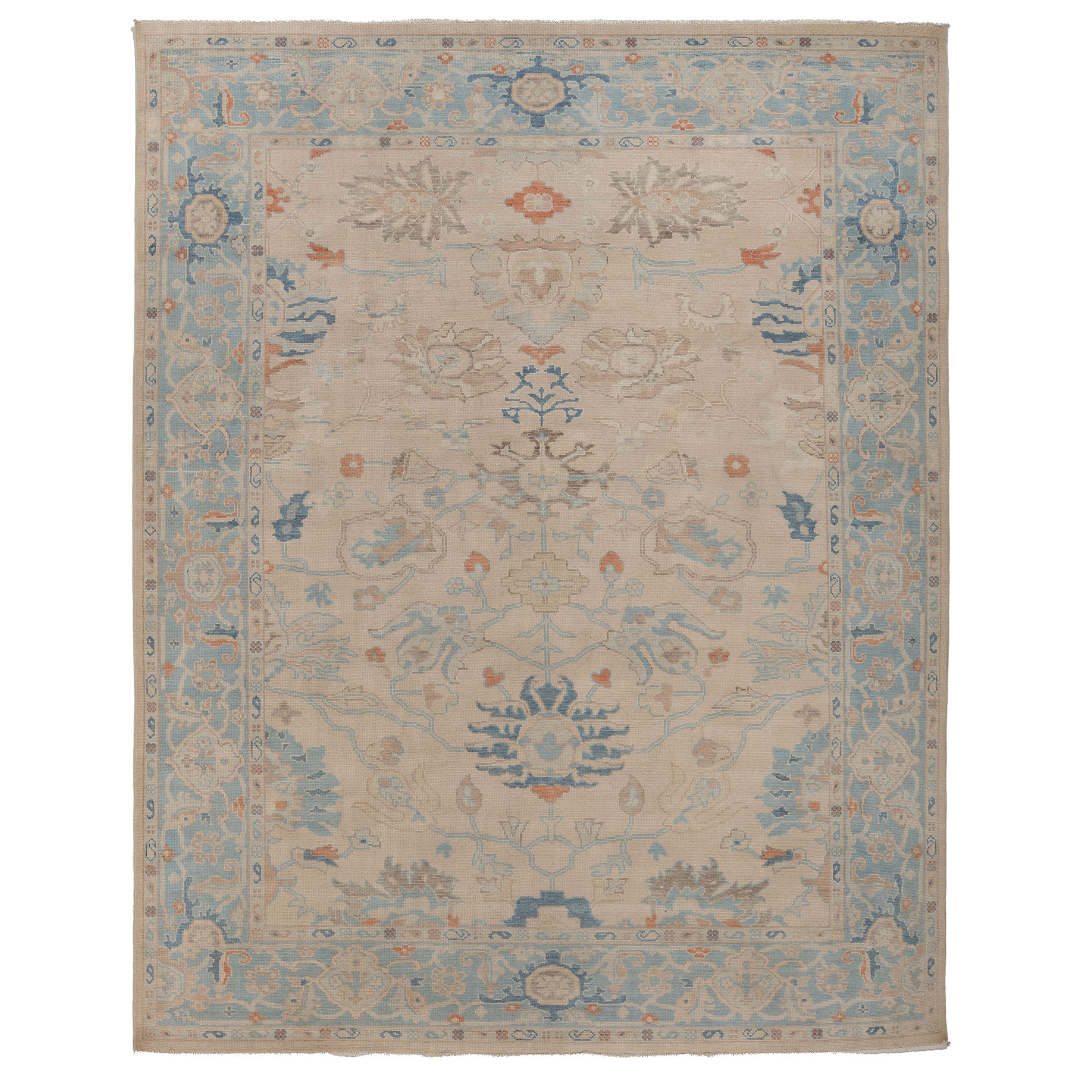 Hand-knotted 9x12 Oushak area rug with an ivory center field, cornflower blue border, and terracotta orange details.