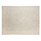Soft seamist green 9x12 Oushak area rug with cream floral medallions and a wide cream border.