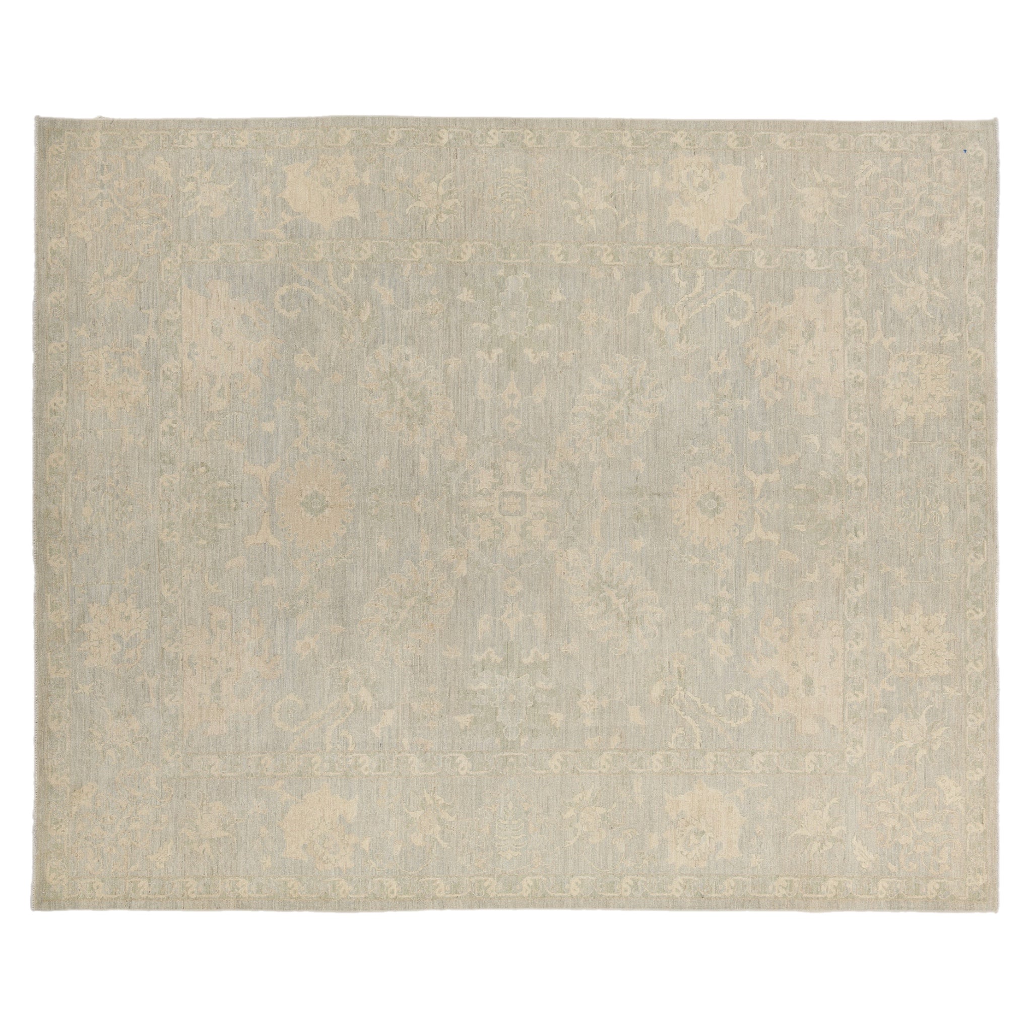 Muted celadon green 8x10 Oushak area rug with cream and taupe floral medallions.