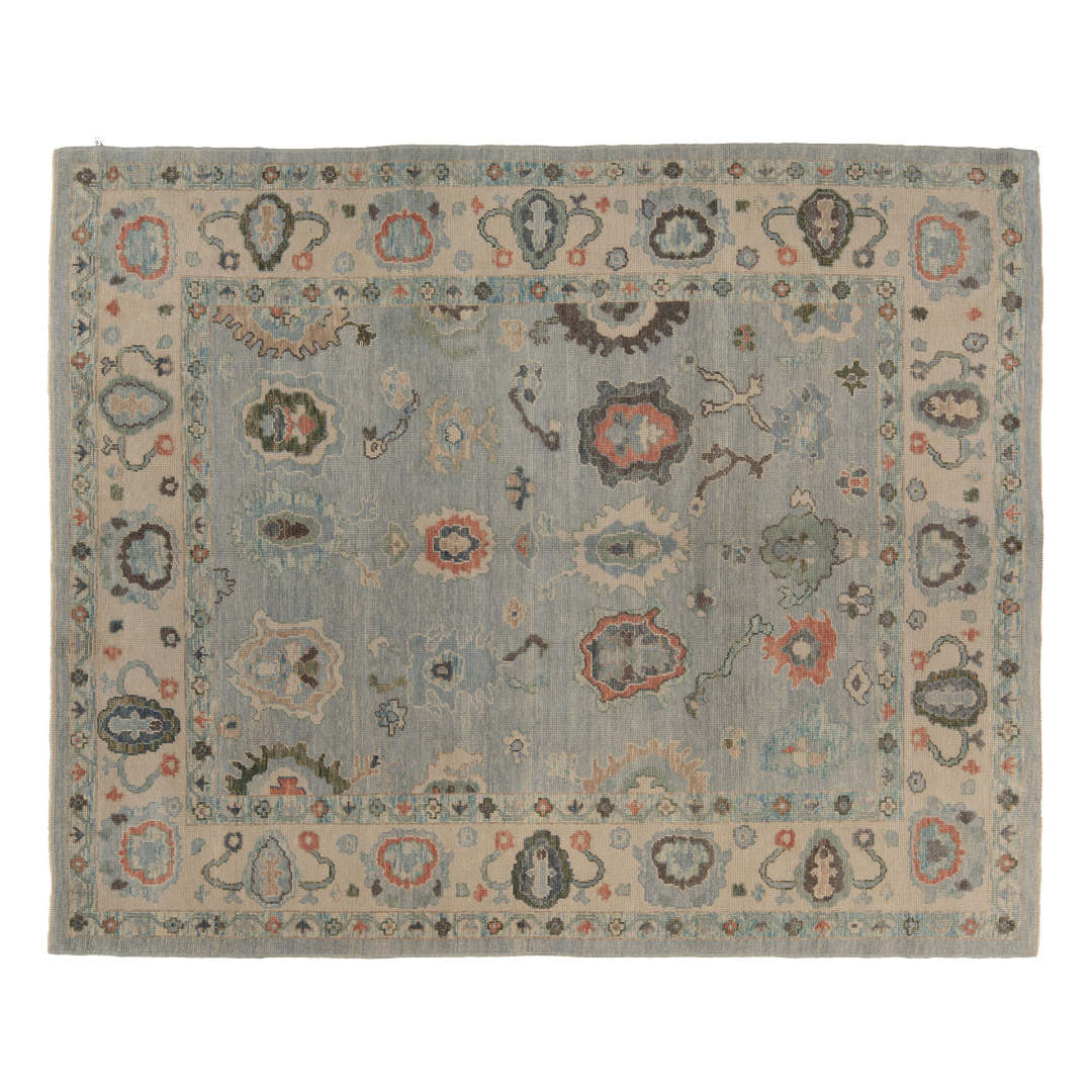 Light blue 8x10 Oushak area rug featuring floating coral and charcoal star cartouches surrounded by a wide beige border.