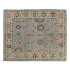 Light blue 8x10 Oushak area rug featuring floating coral and charcoal star cartouches surrounded by a wide beige border.