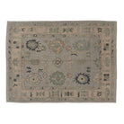 Light blue 6x9 Oushak area rug with sage green and cream scalloped medallions and charcoal accents.