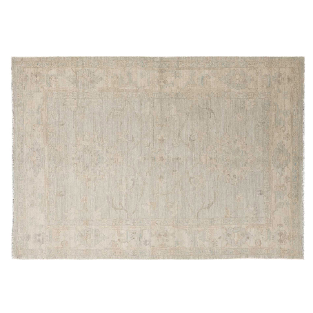 Faded soft blue green 5x7 Oushak area rug with delicate ivory motifs and a warm beige border.