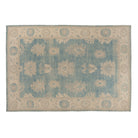Medium blue 10x14 Oushak area rug with strié texture, beige floral palmettes, and warm camel accents.