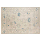 Ultra-faded cream 10x14 Oushak area rug with taupe floral palmettes and french blue accents.