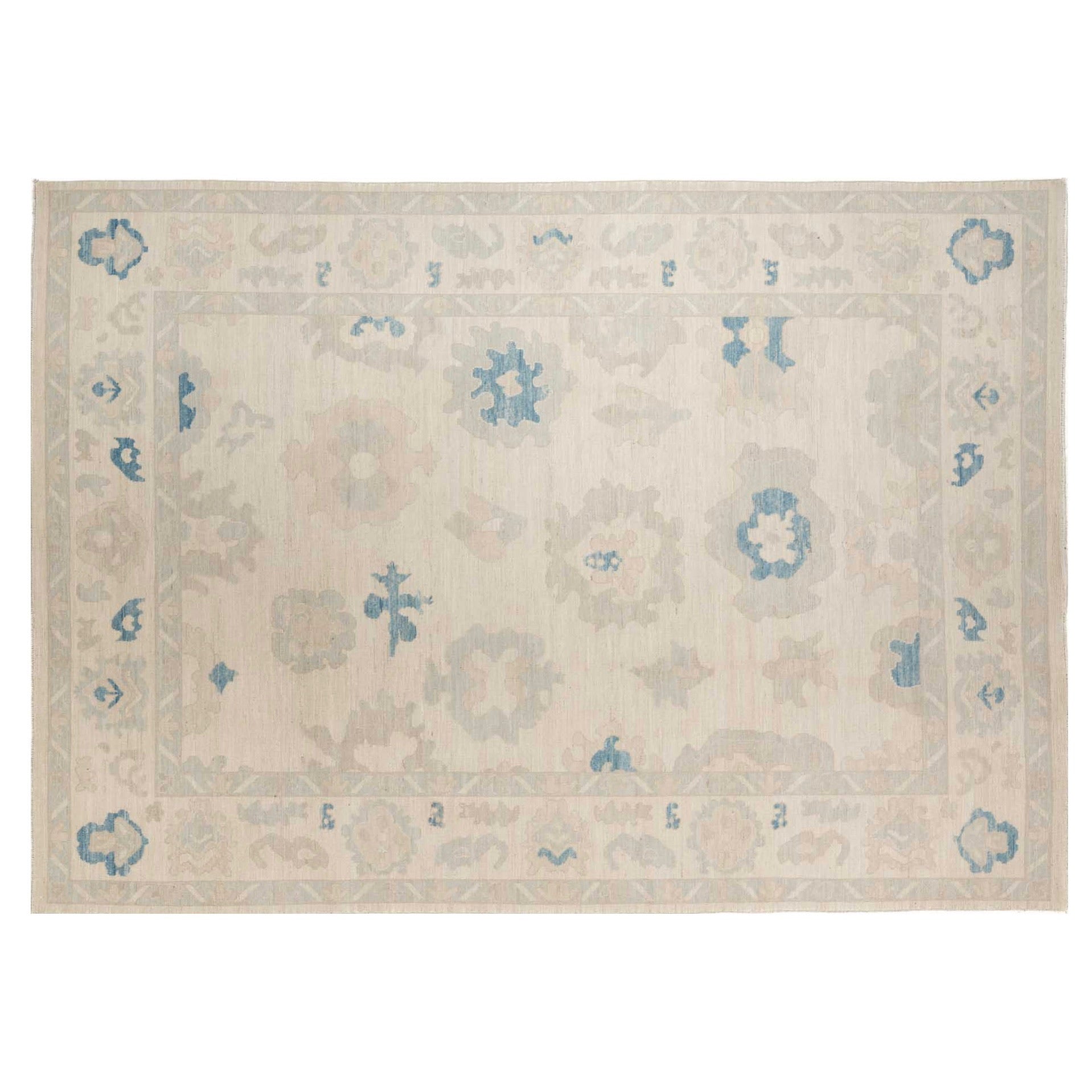 Ultra-faded cream 10x14 Oushak area rug with taupe floral palmettes and french blue accents.