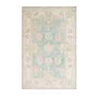 Muted medium blue 4x6 Oushak area rug with warm ivory geometric medallions, botanical details, and a distressed finish.