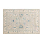 Traditional pale blue 4x6 Oushak area rug with muted ivory motifs and prominent dark blue geometric accents.