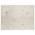 Hand-knotted 9x12 Oushak area rug with a faded sage green field, light blue botanical patterns, and a pale border.