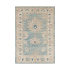 Weathered denim blue 3x5 Oushak area rug with large ivory and sand floral medallions, dark blue accents, and a cream border.