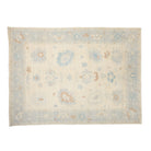 Luminous vanilla 10x14 Oushak area rug with light blue floral cartouches and subtle terracotta accents.