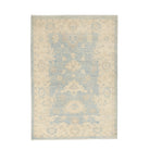 Soft light blue 3x5 Oushak area rug with a muted beige and ivory floral pattern, cream borders, and a distressed low pile finish.