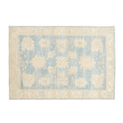 Traditional medium blue 4x6 Oushak area rug with warm beige and cream geometric medallions and a distressed cream border.