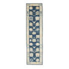 Traditional dark blue Oushak runner rug with a climbing floral motif, peach and beige accents, and a wide ivory border.