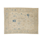 Warm vanilla 9x12 Oushak area rug with light blue floral motifs and dark blue geometric accents.