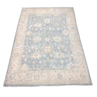 Soft light teal 8x10 Oushak area rug with cream floral palmettes and a broad cream border.