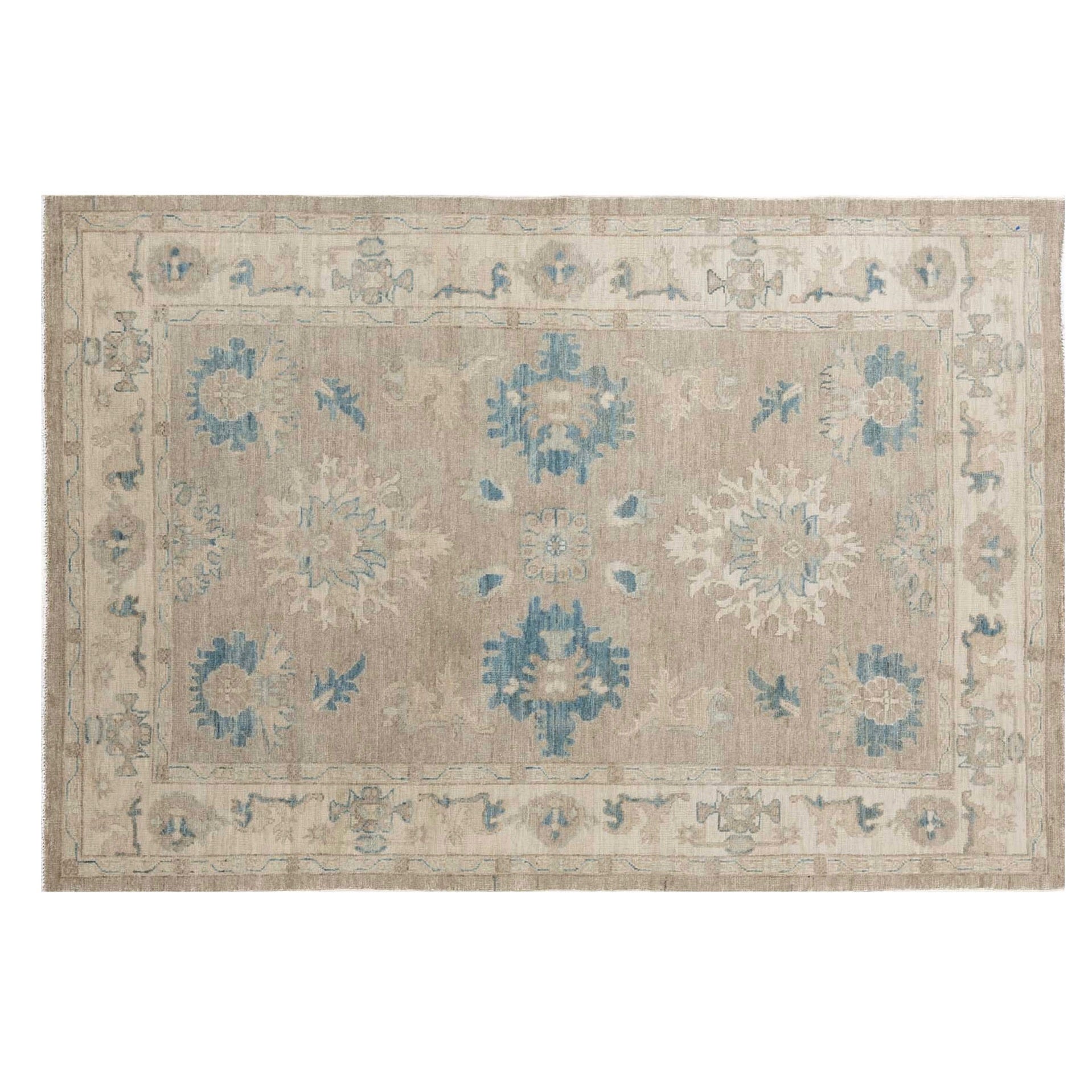 Warm caramel and taupe 5x7 Oushak area rug with teal blue floral medallions and a wide cream border.