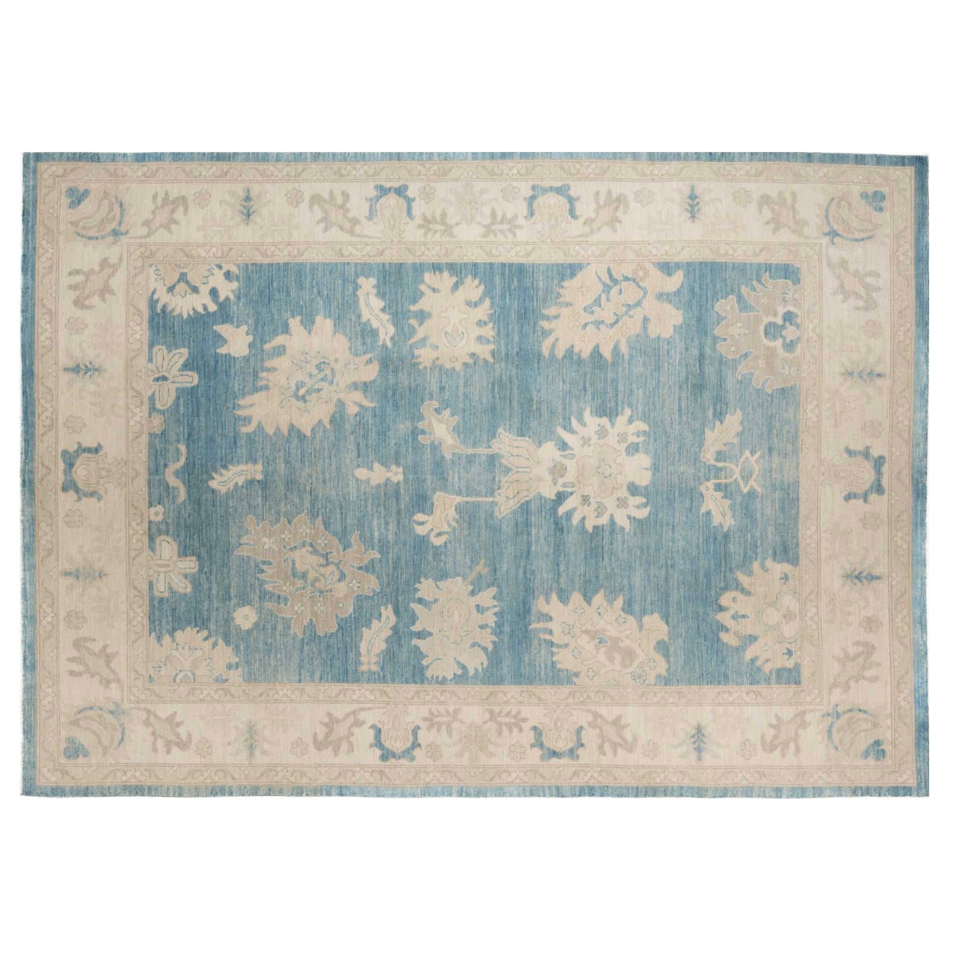 Deep blue 10x14 Oushak area rug with cream and taupe floral palmettes and a broad cream border.