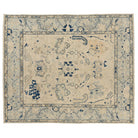 Hand-knotted 8x10 Oushak area rug with a bright ivory center field, navy blue floral details, and pale blue border.