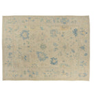 Large sand-beige 9x12 Oushak area rug with sky blue and sage green floral motifs.