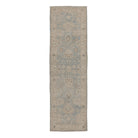 Muted traditional Oushak runner rug featuring a soft ice blue field, warm beige borders, and charcoal accents.