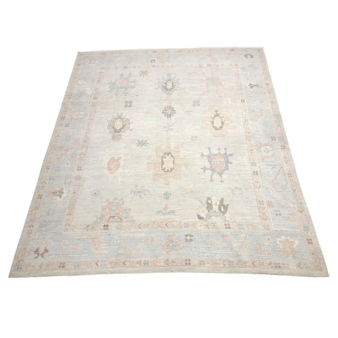Ultra-faded ivory cream 8x10 Oushak area rug with lavender, salmon, and brown geometric star medallions.