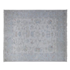 Ultra-faded cream 8x10 Oushak area rug with soft teal blue vine scrollwork and coral pink accents.