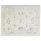 Luminous butter cream 9x12 Oushak area rug with medium blue floral medallions and blush pink accents.