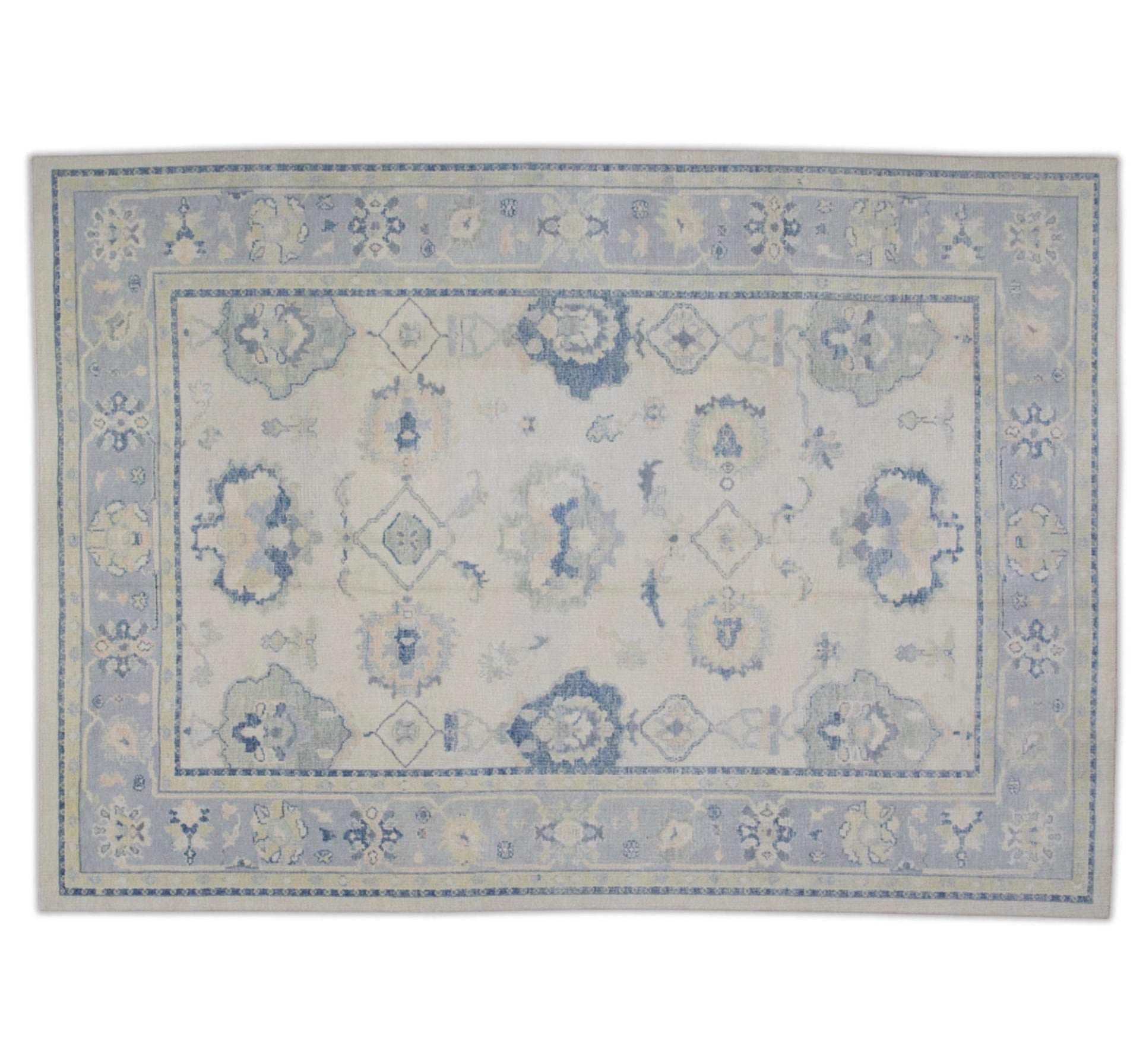 Soft beige 9x12 Oushak area rug with light blue border, green floral palmettes, and dark blue accents.