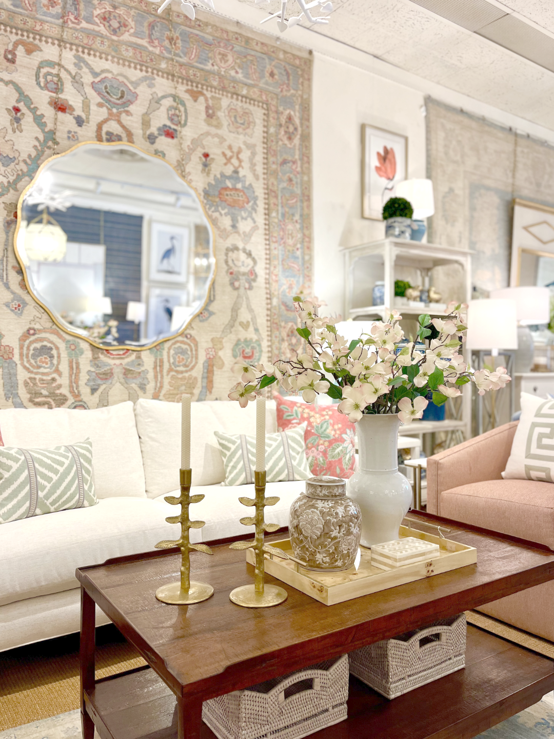 Hand-knotted 9x12 Oushak area rug with an ivory field, multi-color red and peach motifs, and a light blue border. Display with dogwood blooms and gold accents.