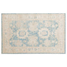 Soft sky blue 4x6 Oushak area rug with cream floral palmettes and a broad beige border.