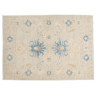 Soft taupe 4x6 Oushak area rug with bold teal blue central palmettes and rust accents.